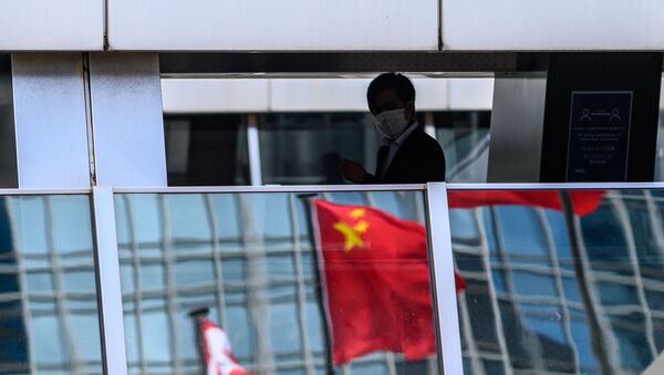 Мужчина проходит мимо отражения китайского флага - Sputnik Абхазия