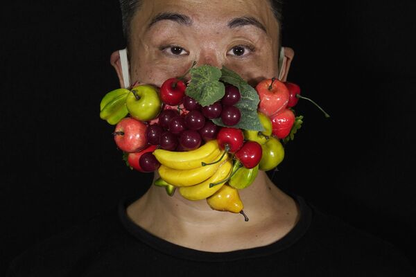 Гонконгский театральный художник по костюмам и актер Эдмонд Кок в маске, украшенной множеством разных фруктов - Sputnik Абхазия
