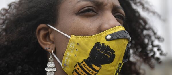 Женщина в маске с надписью Люди не сдаются, черт возьми принимает участие в акции протеста против недавних массовых убийств в Боготе Женщина в маске с надписью Люди не сдаются, черт возьми принимает участие в акции протеста против недавних массовых убийств в Боготе - Sputnik Абхазия