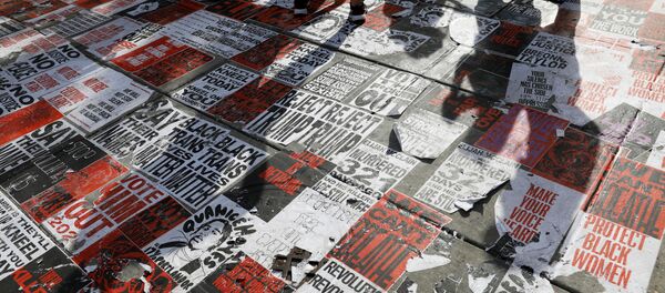 Люди стоят над плакатами BLM на площади Black Lives Matter Plaza во время марша Get Your Knee Off Our Necks в поддержку расовой справедливости возле Белого дома в Вашингтоне Люди стоят над плакатами BLM на площади Black Lives Matter Plaza во время марша Get Your Knee Off Our Necks в поддержку расовой справедливости возле Белого дома в Вашингтоне - Sputnik Абхазия