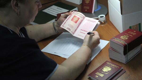 Сотрудница ФГУП Гознак проверяет качество готовых биометрических заграничных паспортов граждан РФ - Sputnik Абхазия