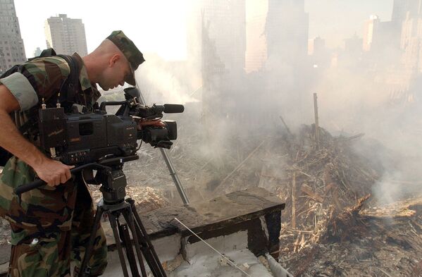 Оператор во время съемки разрушений на месте Всемирного торгового центра после атаки в Нью-Йорке  - Sputnik Абхазия