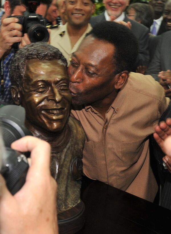 Легенда бразильского футбола Пеле целует свою статую, открытую в Либревиле 9 февраля 2012 года, за три дня до финала Кубка африканских наций. - Sputnik Абхазия