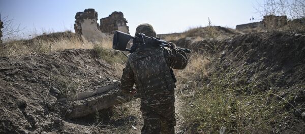 Армянский солдат несет свой автомат в передней линии, как войска занимают должности на 18 октября 2020 года, в ходе продолжающихся боевых действий между Арменией и Азербайджаном по поводу спорного региона  Армянский солдат несет свой автомат в передней линии, как войска занимают должности на 18 октября 2020 года, в ходе продолжающихся боевых действий между Арменией и Азербайджаном по поводу спорного региона - Sputnik Аҧсны