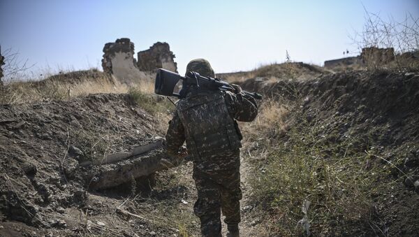  Армянский солдат несет свой автомат в передней линии, как войска занимают должности на 18 октября 2020 года, в ходе продолжающихся боевых действий между Арменией и Азербайджаном по поводу спорного региона - Sputnik Аҧсны