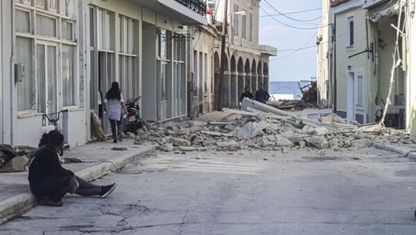Люди проходят мимо разрушенного дома после землетрясения на острове Самос 30 октября 2020 года - Sputnik Аҧсны