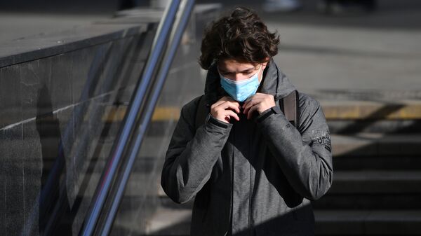 Молодой человек в защитной маске на улице в Москве. - Sputnik Абхазия