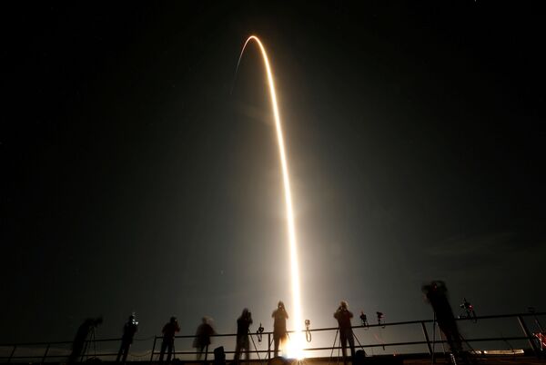 Люди наблюдают за запуском ракеты SpaceX Falcon 9 с капсулой Crew Dragon с четырьмя астронавтами в Космическом центре Кеннеди на мысе Канаверал, Флорида, США - Sputnik Абхазия
