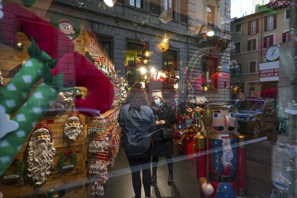 Покупательница разговаривает с продавщицей в полупустом магазине рождественских украшений в Риме - Sputnik Абхазия