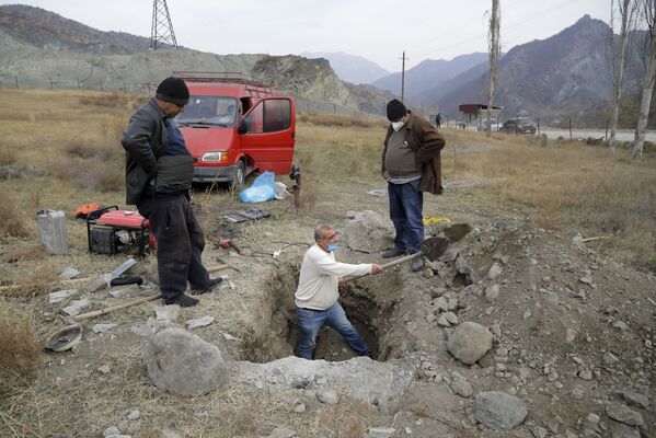 Местные жители села Кельбаджар выкапывают гроб с похороненным родственником, чтобы вывезти его останки - Sputnik Абхазия