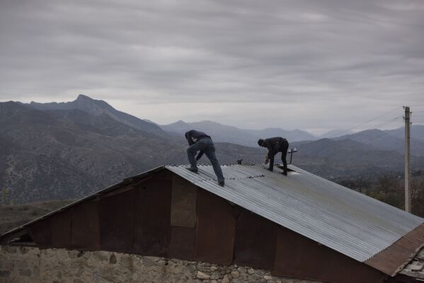 Мужчины разбирают крышу дома в поселке Карегах - Sputnik Абхазия
