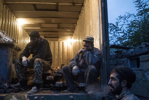 Местные жители отдыхают во время погрузки личных вещей в грузовик в поселке Карегах - Sputnik Абхазия