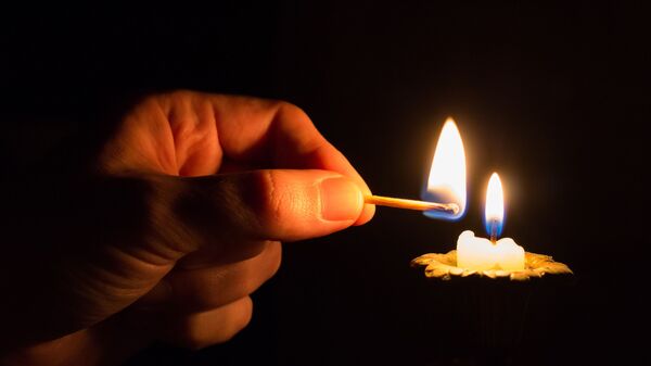 Человек зажигает свечу - Sputnik Абхазия
