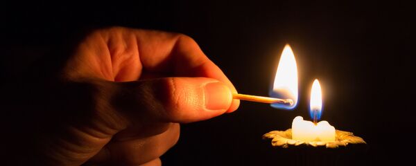 Человек зажигает свечу Человек зажигает свечу - Sputnik Абхазия