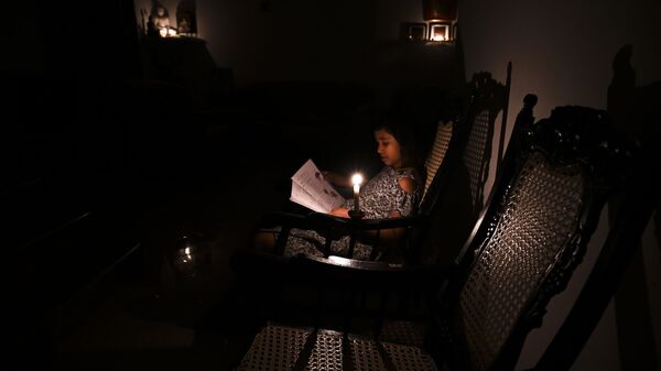 Девушка читает книгу при свете свечи во время отключения электричества в Биягаме, пригороде столицы Коломбо, 18 августа 2020 года - Sputnik Абхазия