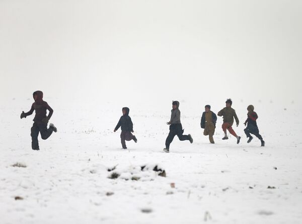 Афганские мальчики играют во время снегопада в Кабуле - Sputnik Абхазия