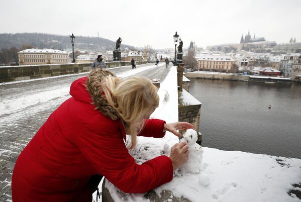 Женщина лепит снеговика на Карловом мосту в Праге, Чехия - Sputnik Абхазия