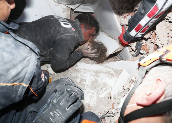 Турецкие спасатели вытаскивают ребенка из под обломков после землетрясения в Измире - Sputnik Абхазия