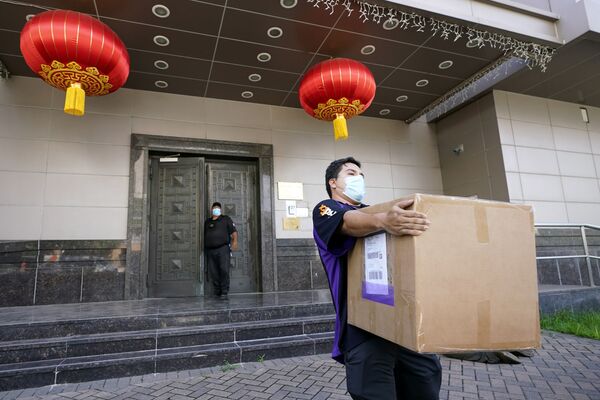 Сотрудник FedEx забирает коробку из консульства Китая в Хьюстоне - Sputnik Абхазия