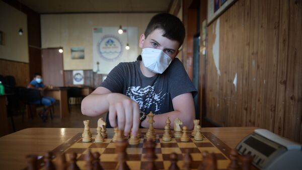 Ребенок в защитной маске играет в шахматы  - Sputnik Абхазия