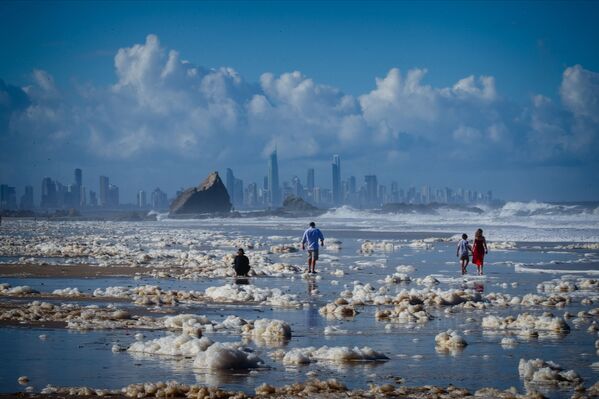 Туристы гуляют среди пены на пляже после циклона на пляже в Австралии - Sputnik Абхазия