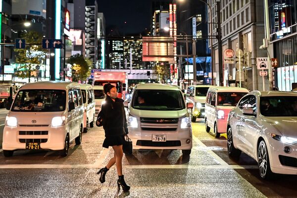 Женщина в защитной маске переходит дорогу в Токио - Sputnik Абхазия