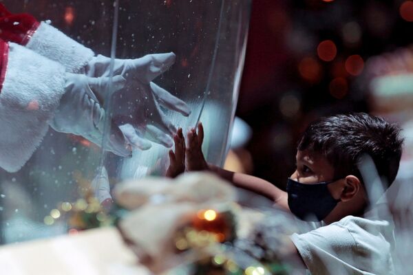Ребенок общается с Санта Клаусом через пластиковый экран в шоппинг-центре в Бразилии - Sputnik Абхазия