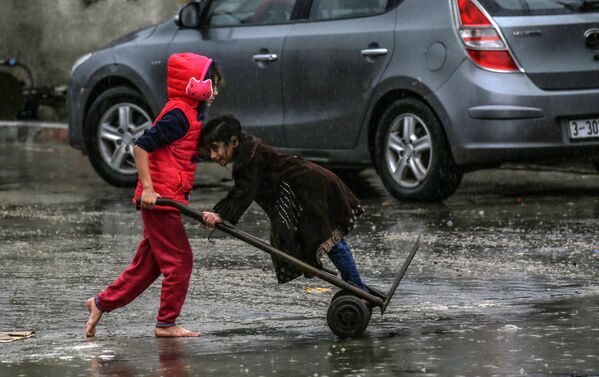 Палестинские дети в дождливый день в Рафахе на юге сектора Газа - Sputnik Абхазия