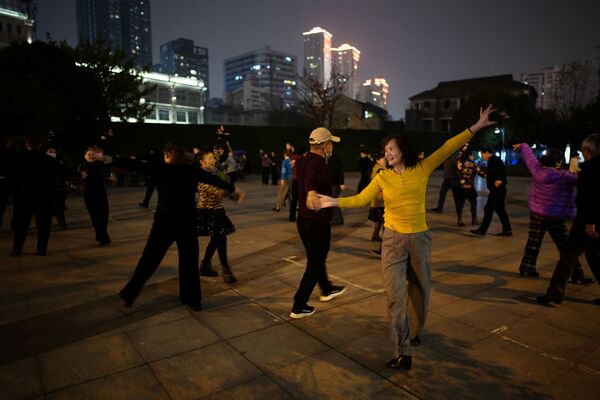 Люди танцуют ночью парке спустя год после вспышки COVID-19 в Ухане - Sputnik Абхазия