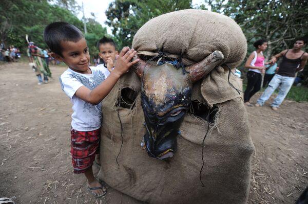 Мальчик играет с участником фестиваля Feast of the Devils в костюме быка в Коста-Рике  - Sputnik Абхазия