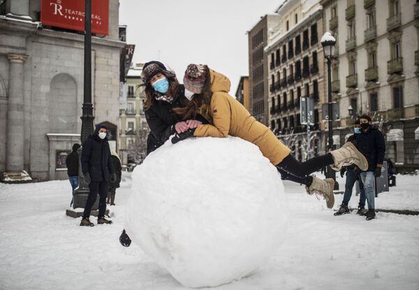 Девушки прыгают на гигантский снежок на одной из улиц в Мадриде - Sputnik Абхазия