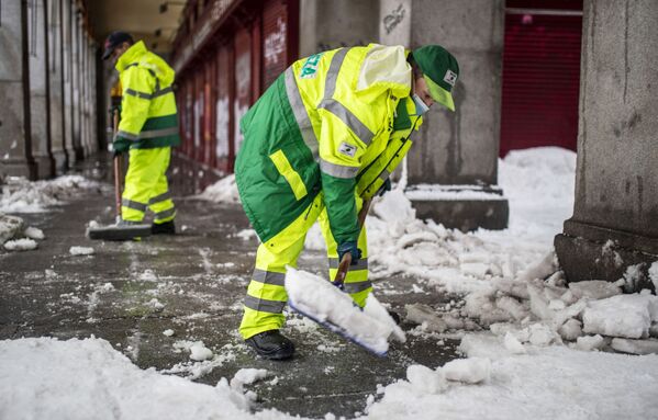 Сотрудники коммунальных служб убирают последствий снегопада на одной из улиц в Мадриде - Sputnik Абхазия