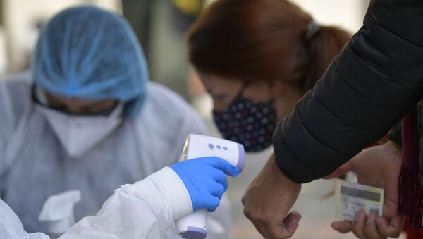 Медицинский работник измеряет температуру тела перед прохождением теста на коронавирус COVID-19 в Боготе 15  - Sputnik Аҧсны
