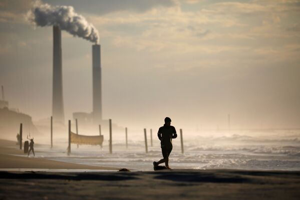 Мужчина бежит по пляжу в Ашкелоне во время третьего локдауна в Израиле - Sputnik Абхазия