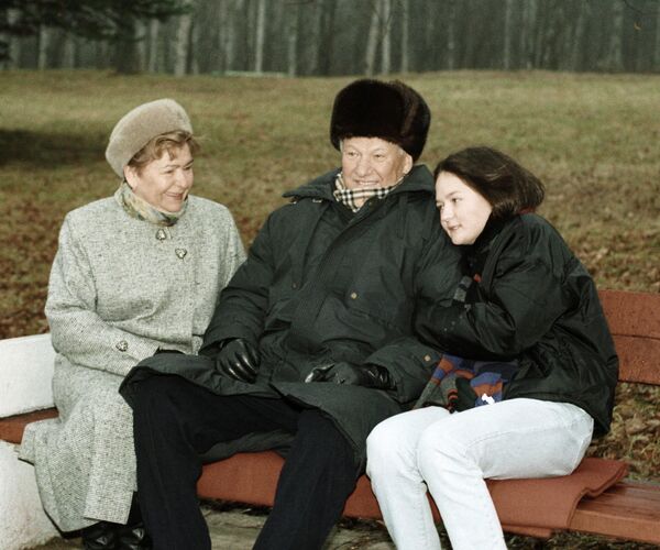 Президент РФ Борис Ельцин (в центре) сидит на скамье во время прогулки с супругой Наиной (слева) и внучкой Машей (справа). - Sputnik Абхазия