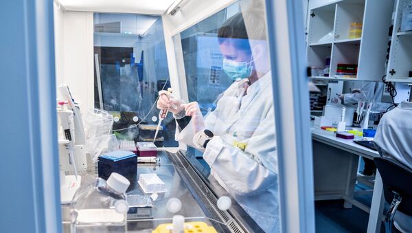 Исследователь из Университета Ольборга стоит за экраном безопасности, чтобы проверить и проанализировать все положительные образцы датского коронавируса на кластер вариантов вируса B117 из Соединенного Королевства, в Ольборге, Дания - Sputnik Абхазия
