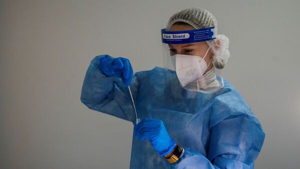 Медицинский работник в защитных средствах (СИЗ) смешивает образец, взятый у пациента, в раствор во время проведения экспресс-теста на антиген на коронавирус (Covid-19) в центре тестирования в Берлине - Sputnik Абхазия