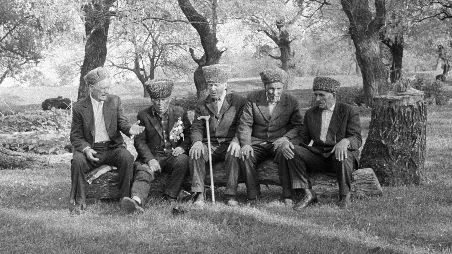 Долгожители аула Пшизов сидят на бревне. - Sputnik Аҧсны, 1920, 24.07.2022