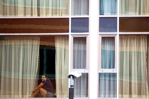 Женщина смотрит из окна отеля Radisson Blu в аэропорту Хитроу, Лондон, Великобритания - Sputnik Абхазия
