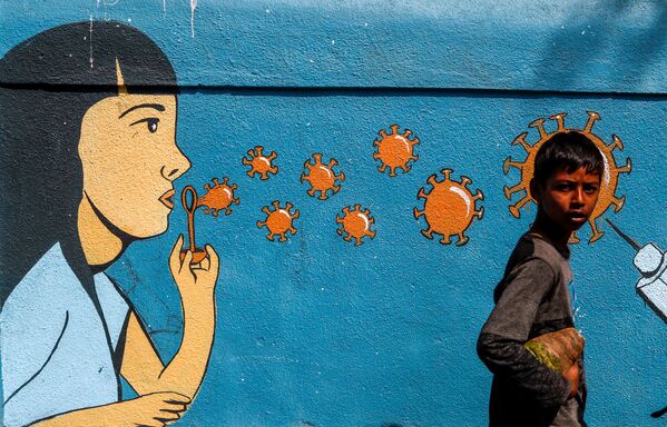 Мальчик проходит мимо граффити в Мумбаи, Индия - Sputnik Абхазия