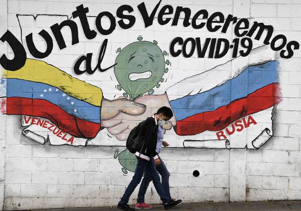 Граффити с изображением флагов Венесуэлы и России с надписью «Вместе мы победим COVID-19» в Каракасе - Sputnik Абхазия