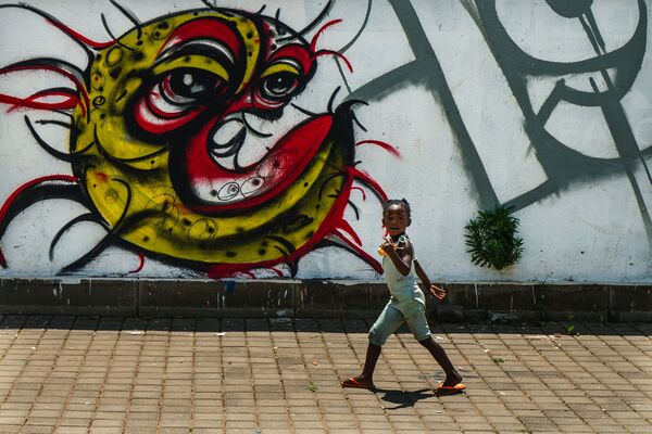Ребенок у граффити с изображением COVID-19 в Совето, ЮАР - Sputnik Абхазия