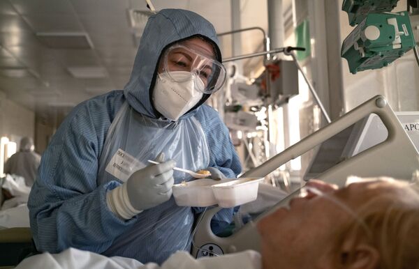 Медсестра кормит пациента в отделении реанимации и интенсивной терапии в больнице в Москве - Sputnik Абхазия