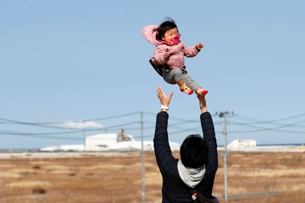Потерявший родных во время землетрясения 2011 года отец с ребенком в префектуре Фукусима  - Sputnik Абхазия