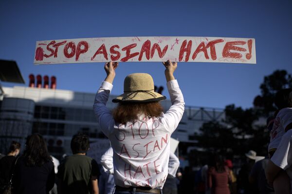 Девушка с плакатом во время акции Stop Asian Hate в США - Sputnik Абхазия
