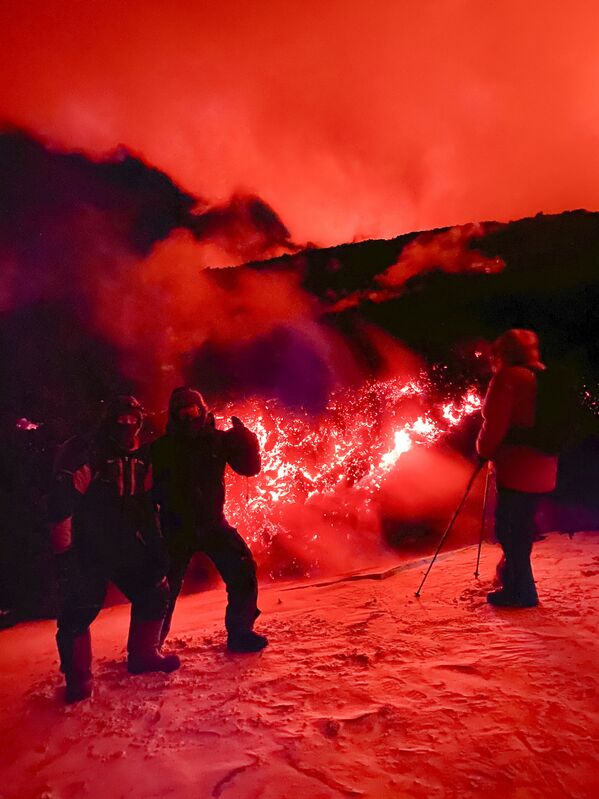 Туристы позируют для фото во время извержения вулкана Ключевская на полуострове Камчатка в России - Sputnik Абхазия