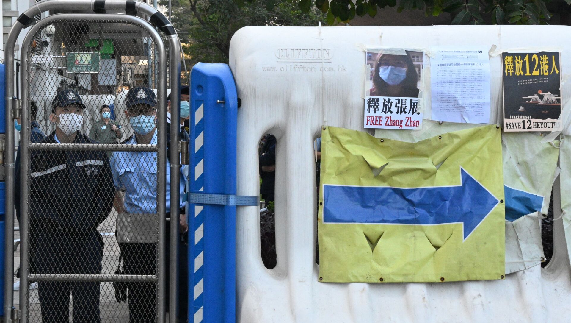 Полицейские смотрят на протестующих, держащих плакаты возле китайского офиса связи в Гонконге 28 декабря 2020 года, призывающих Китай освободить группу гонконгских активистов демократии, предстающих перед судом в Китае, после того, как они попытались бежать с территории на скоростном катере на Тайвань в августе прошлого года - Sputnik Абхазия, 1920, 15.04.2021