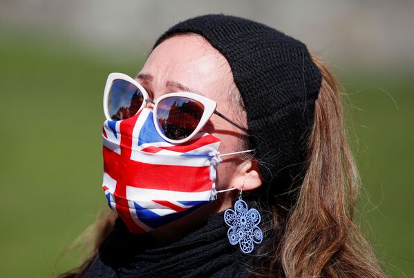 Женщина в маске у Виндзорского замка во время похорон британского принца Филиппа - Sputnik Абхазия