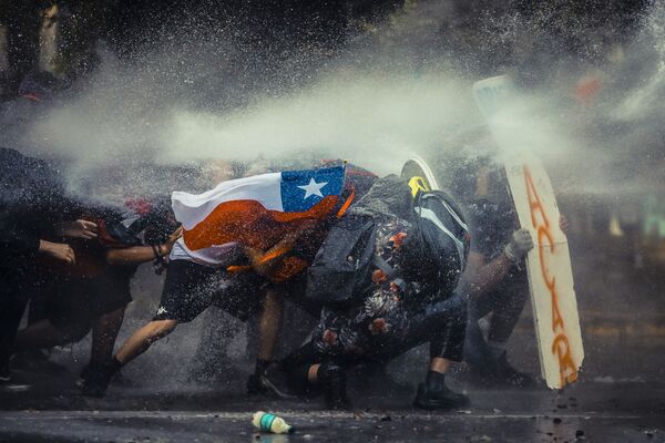 На пятом месте оказалась работа чилийского фотографа Хавьера Вергары (Javier Vergara), посвященная протестам в Сантьяго. - Sputnik Абхазия