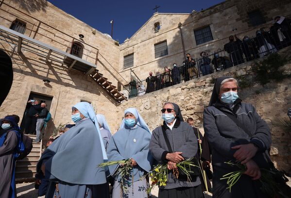 Христианские монахини молятся во время службы в Вербное воскресенье на Елеонской горе с видом на Старый город Иерусалима. - Sputnik Абхазия